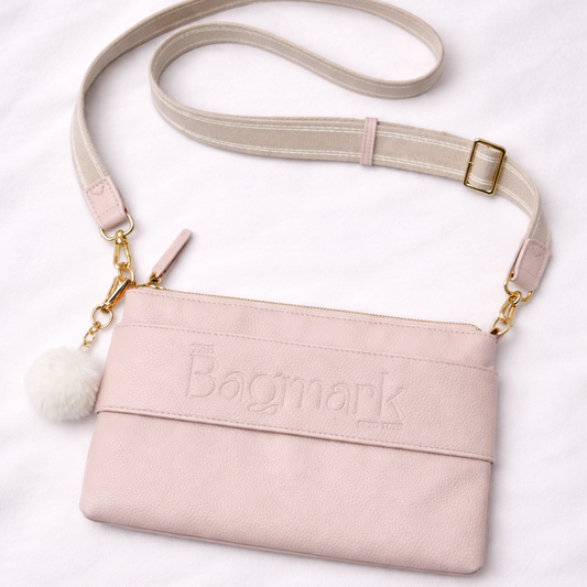 Pink handbag with adjustable strap on a white background